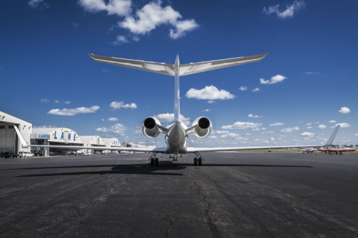 Rear view of private jet parked on runway at Lane Aviation Columbus FBO with hangars in background
