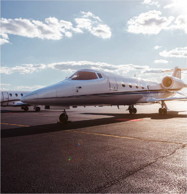Private jet parked on an airport tarmac in bright daylight.